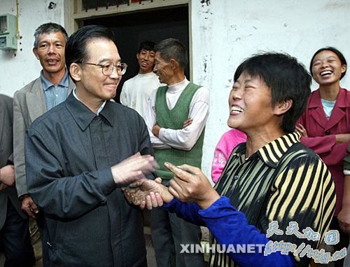 2003年10月24日,温总理看望云阳县龙泉村村民。温总理和大家一一握手,刚干完农活的熊德明怕自己手脏,直往后