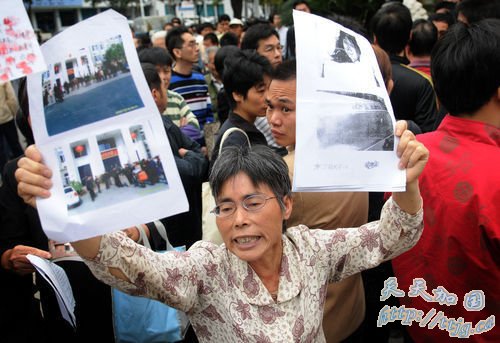 11月11日,死者严晓玲的母亲林秀英手举诉讼材料。