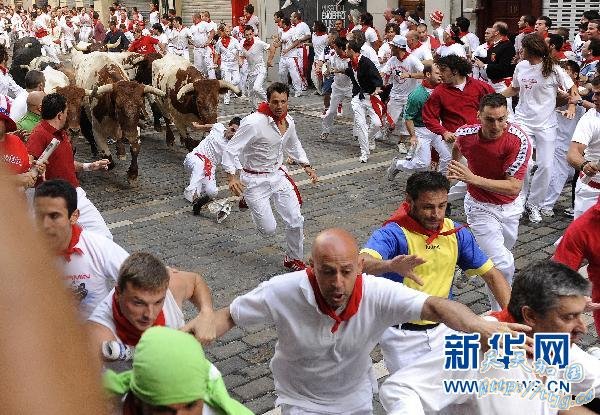 7月8日,在西班牙城市潘普洛纳,人们在奔牛节上躲避公牛的追逐。 新华社/法新 7月8日,在西班牙城市潘普洛纳,人们在奔牛节上躲避公牛的追逐。 新华社/法新